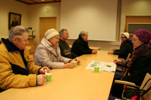 Pöydän äärellä Pentti Hevonoja (vas.), Sirkka Mäkinen, Tauno ja Arja Tauvo ja toisella puolella pöytää Rauha Lehtonen ja Kirsti Kristeri. Pöytäseuruetta puhuttivat sää ja Akaan surkea menestys kuntakyselyssä. Tauvojen mielestä Akaan miinuspuoliin kuuluvat homekoulut ja Viialan terveysaseman sulkemisaikeet. He muistuttavat, että jos Akaa yhdistyy Valkeakoskeen, sinne kulkeminen on autottomilla hankalaa. Sirkka Mäkinen kiittelee, että Hämeen Turistiauto jatkaa kaupungin säästösyistä lopettamia uimahallikuljetuksia. – Kaupungille ollaan vähän näreissään. Nyt näytimme, että päästään me sinne ilmankin. Kiitollisia ollaan Joupin Erkille.