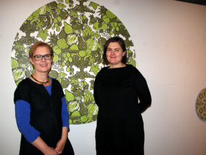 Hanna van Ingen (vas.) ja Elina Yrjönen ovat kolmannen polven tapettitehtailijoita. Ritva Kronlund on suunnitellut tehtaalle useita malleja, joista taustalla näkyy Hedelmämalja.