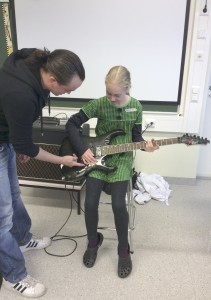 Jesse Riikonen opetti Karita Kajannolle kitaransoittoa Akaan elävän musiikin yhdistys Almun rastilla.