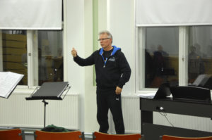 Juha Holma pitää kuorolle äänenavauksen ennen varsinaisia harjoituksia.