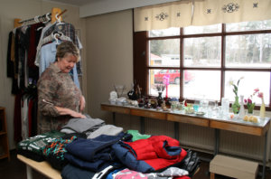 Entiseen opettajanhuoneeseen on kerätty tavaraa ja vaatteita myytäväksi pöydille ja rekkeihin.